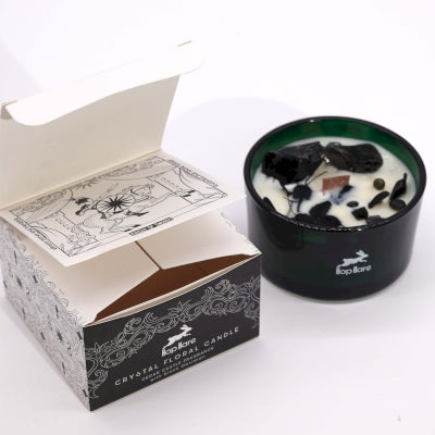 Candle in a black container with a decorative box on a white background